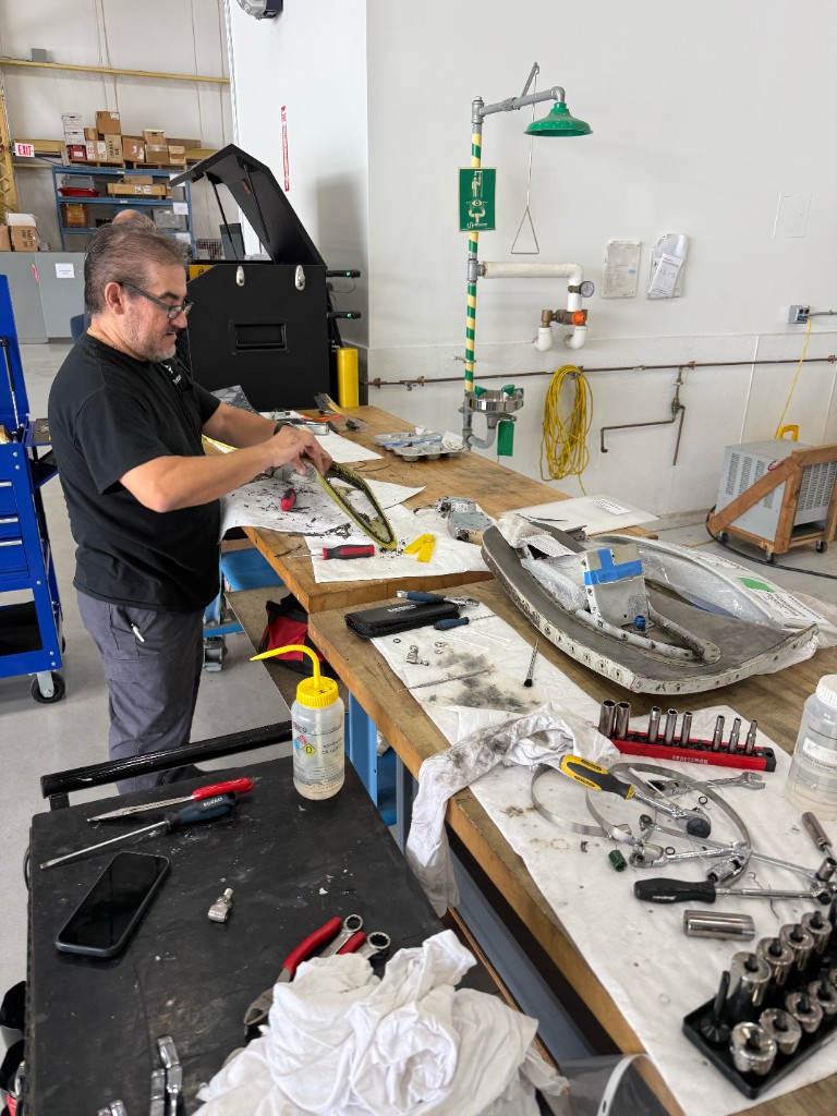 Technician working on a component at the hangar bench