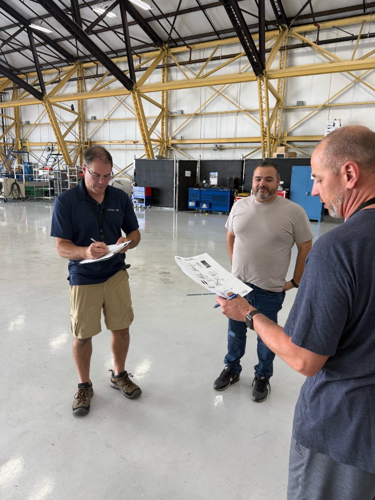 Team reviewing paperwork on the hangar floor